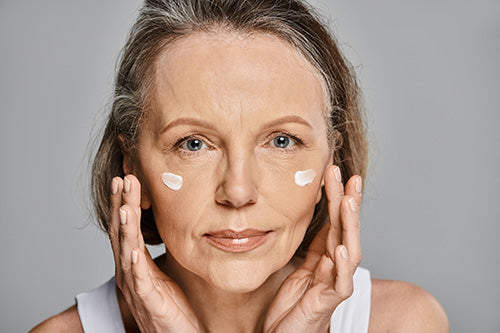 Woman applying cream to face