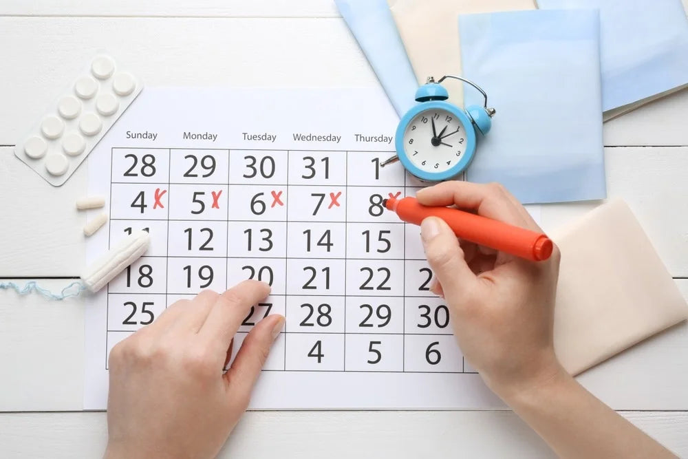 Woman marking a calendar to mark her menstrual cycle
