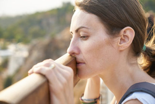 Woman looking over a fence at nature