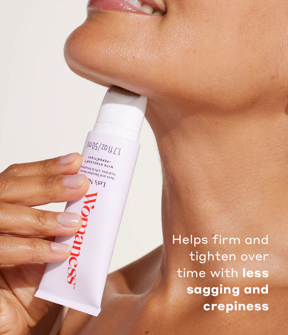 Close-up of Womaness Let’s Neck neck and décolleté serum bottle with a swatch of the creamy serum texture on the white surface beside it. The bottle's pink and white design highlights the product’s purpose as a neck and décolleté treatment.