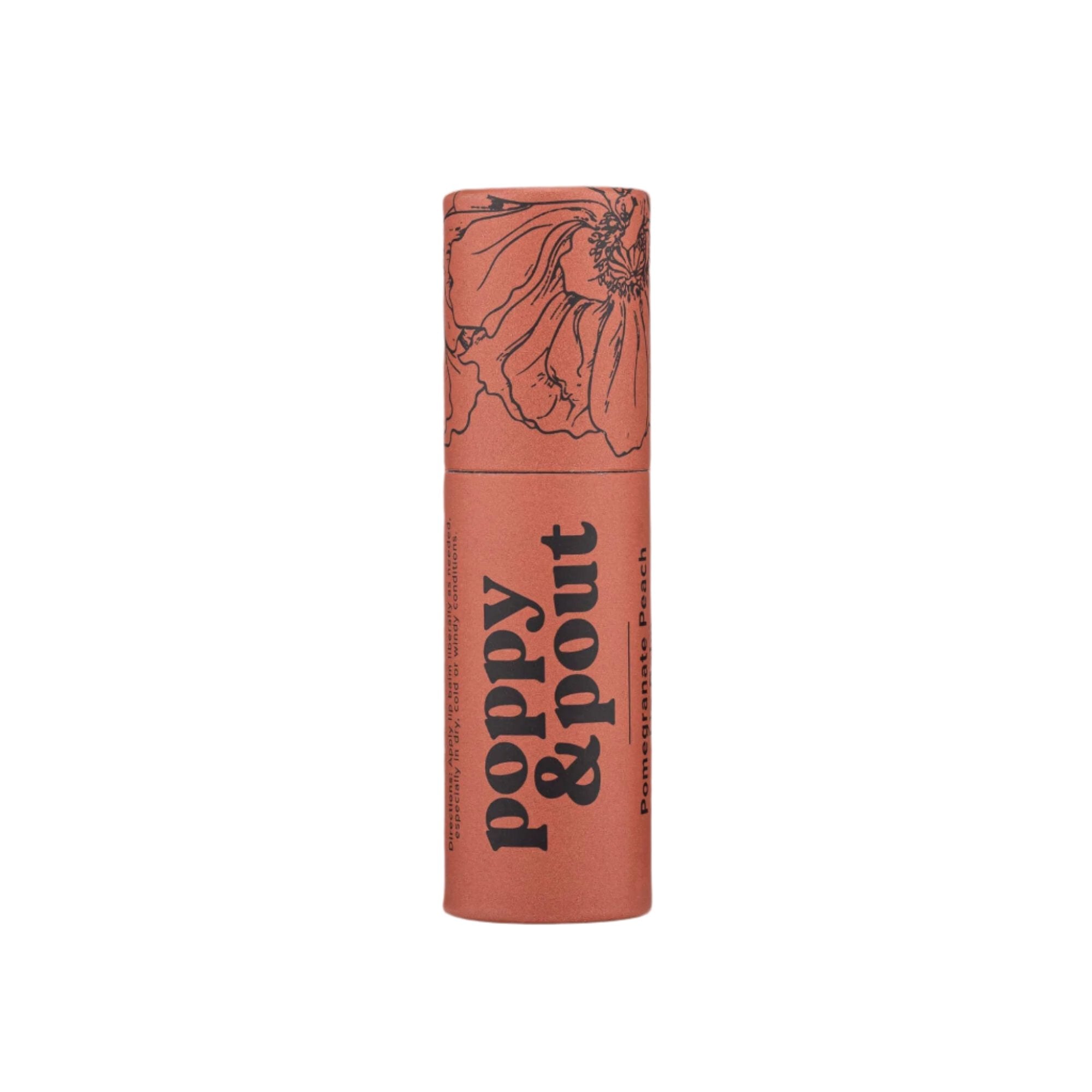 Tube of Poppy & Pout Pomegranate Peach Lip Balm on a white background. The eco-friendly cardboard tube features a floral design with black text, offering a hydrating balm made from natural ingredients with a fruity pomegranate and peach scent.