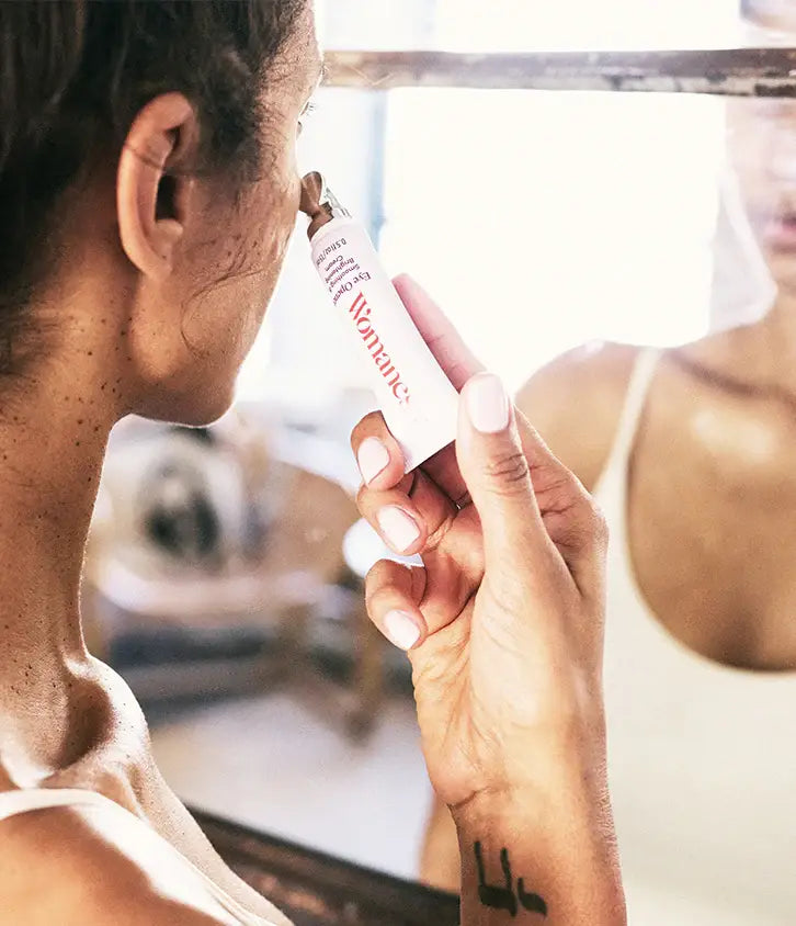 three quarter view of Woman applying Eye Opener Smoothing and Brightening Cream to her under-eye area