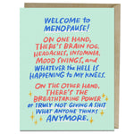 A greeting card that reads: "Welcome to menopause! On one hand, there’s brain fog, headaches, insomnia, mood swings, and whatever the hell is happening to my knees. On the other hand, there’s the breathtaking power of truly not giving a s*t what anyone thinks anymore." Behind the card is a brown craft envelope.