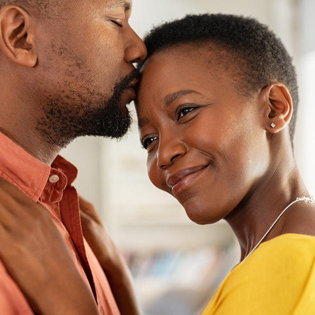 Romantic mature man kissing woman on forehead. Loving couple enjoying spending time together. 