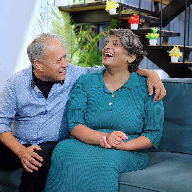 Indian husband and wife sitting on sofa talking