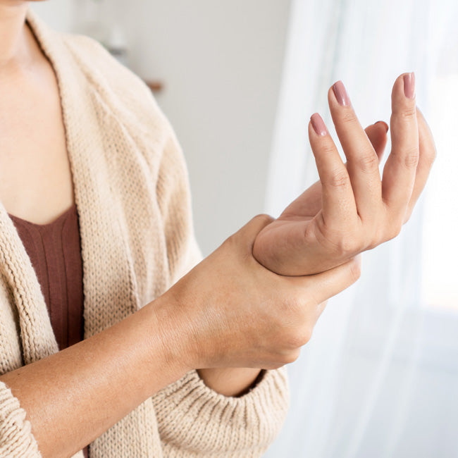 woman suffering from wrist pain in hand holding her ache joint