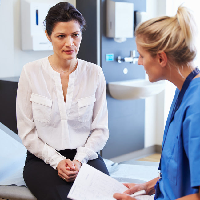 Middle aged woman talking with her female doctor