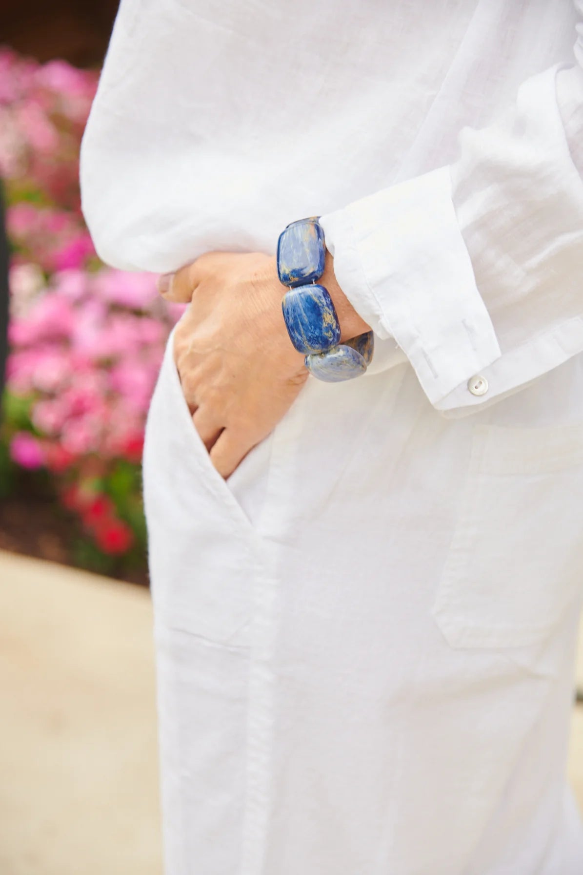 Woman wearing the Hot Girls Pearls Chicklet Cooling Bracelet in Blue Lapis with one hand in her pocket, offering a casual, stylish look while providing relief from hot flashes. This discreet cooling bracelet is designed for women seeking a blend of comfort, fashion, and hot flash relief.